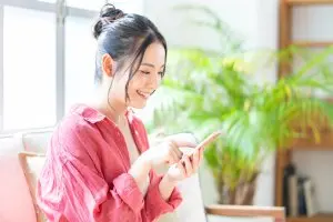 携帯で調べ物をする女性