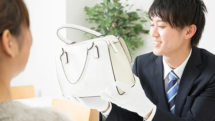 バッグを査定中の査定士