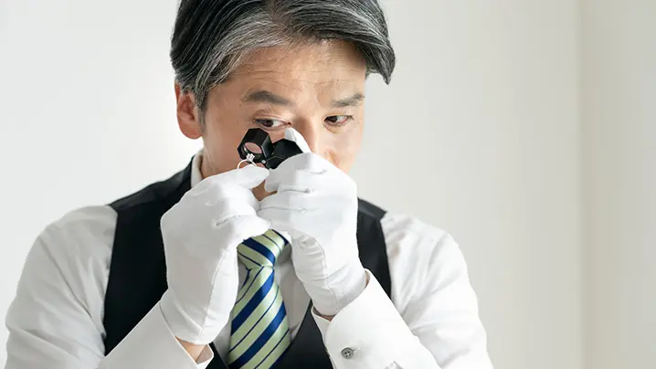 アクセサリーを鑑定する査定士