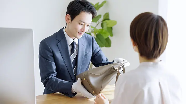 バックを査定する査定士とお客様